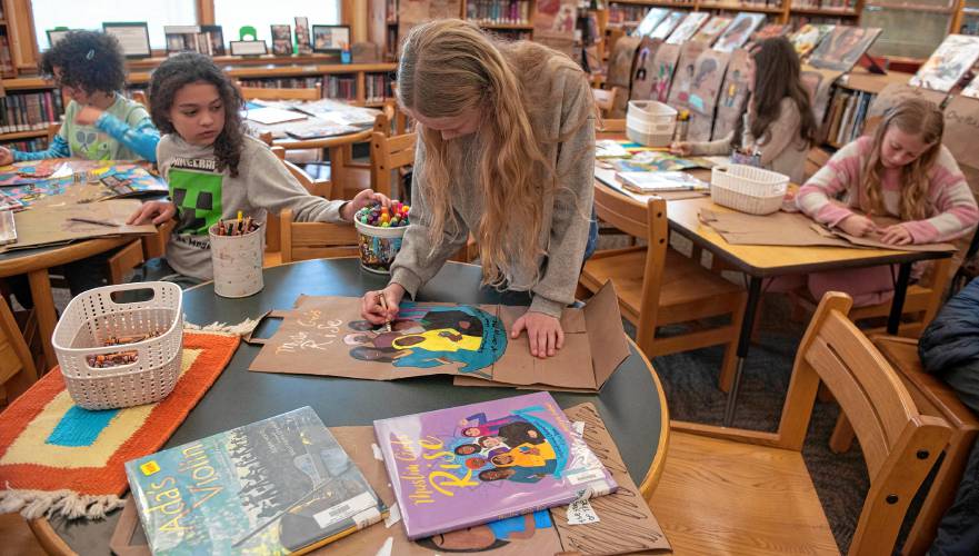 Molly Valentine, a Crocker Farm Elementary student, works with other students on panels for the Memory Project spearheaded by librarian and teacher Waleska Santiago-Centeno. 