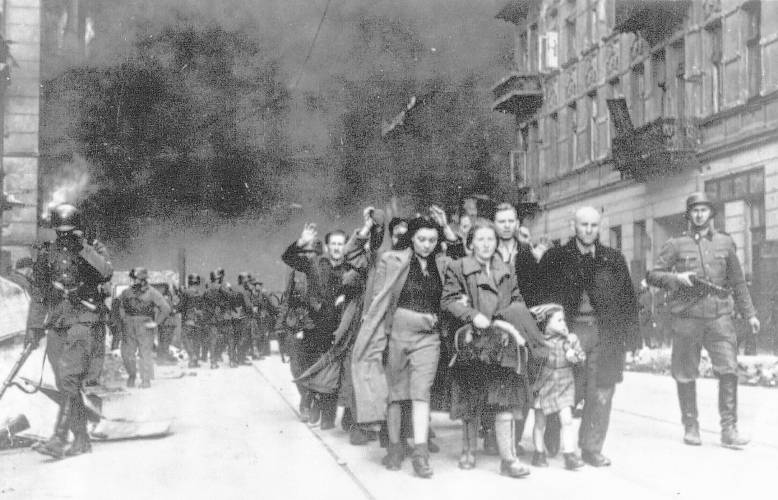 FILE - In this 1943 file photo, a group of Polish Jews are led away for deportation by German SS soldiers during the destruction of the Warsaw Ghetto by German troops after an uprising in the Jewish quarter ghetto by German soldiers on April 19, 1943. Almost 80 years after the Holocaust, about 245,000 Jewish survivors are still living across more than 90 countries, according to the report by the New York-based Conference on Jewish Material Claims Against Germany. (AP Photo, File)