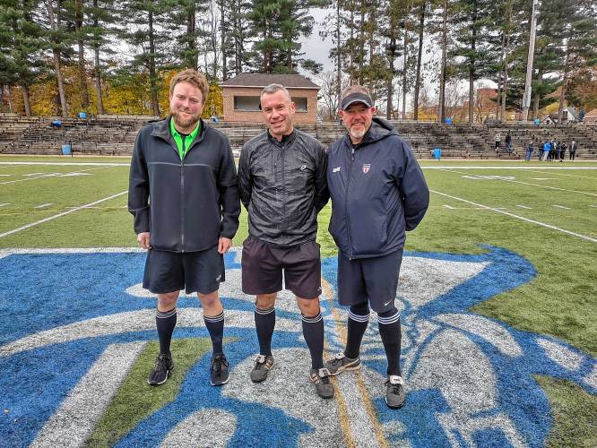 Dan Peters, center, stands between referees John Ashmore, left, and BJ Guerin at right on the soccer field.