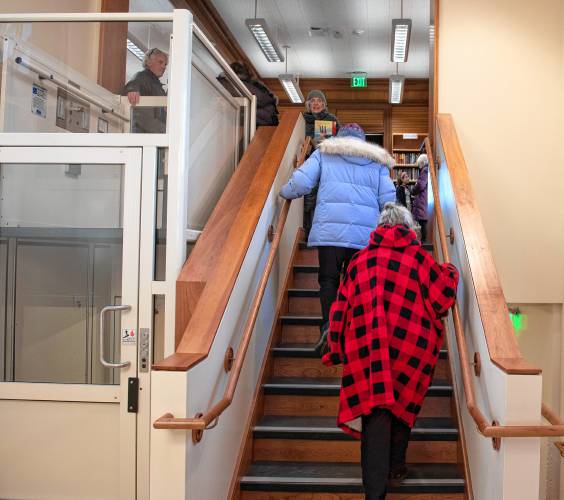 Barbara and Jocelyn Ford walk up the stairs during the reopening of the North Amherst Library on Monday. 