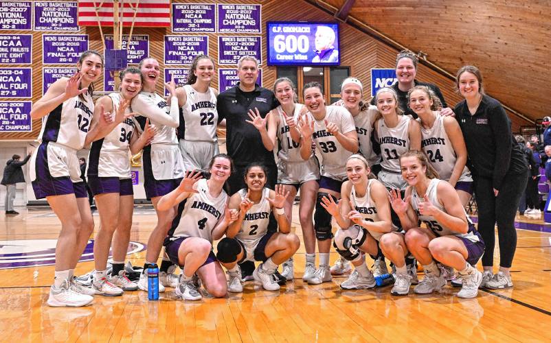 Amherst College women’s basketball coach G.P. Gromacki poses with his team following last week’s win over Connecticut College at LeFrak Gymnasium in Amherst. The victory was No. 600 for Gromacki.