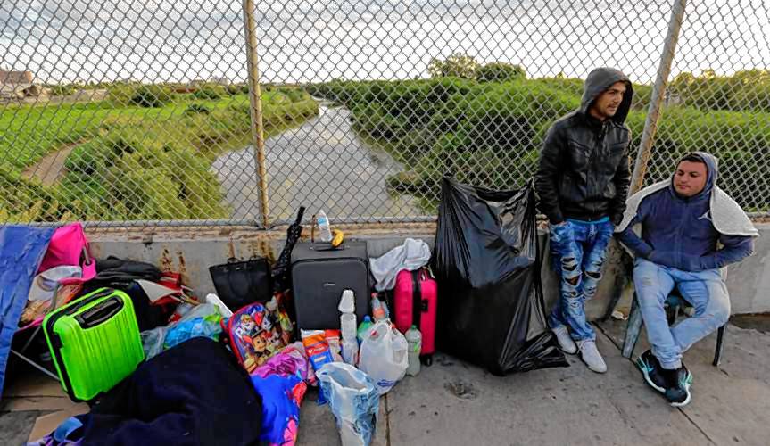 In this photo from 2018, Yenly Morales, left, and Yenly Herrera, right, Cuban immigrants seeking asylum in the United States, wait on the Brownsville and Matamoros International Bridge in Matamoros, Mexico.